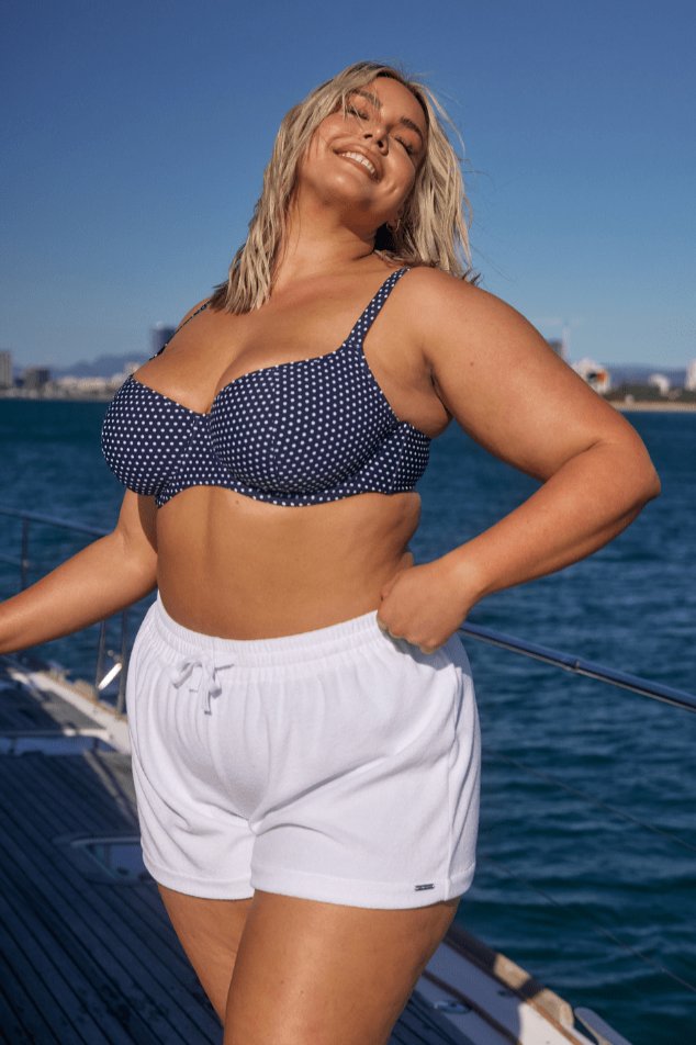 Blonde curve model wearing plus size beach shorts in white terry towelling