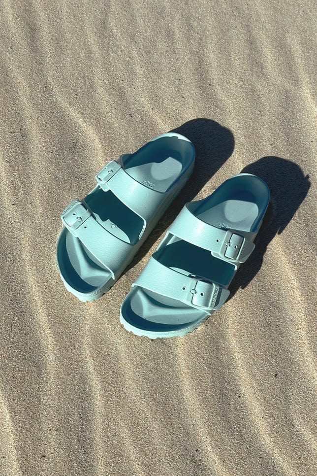 Light teal sandals on beach