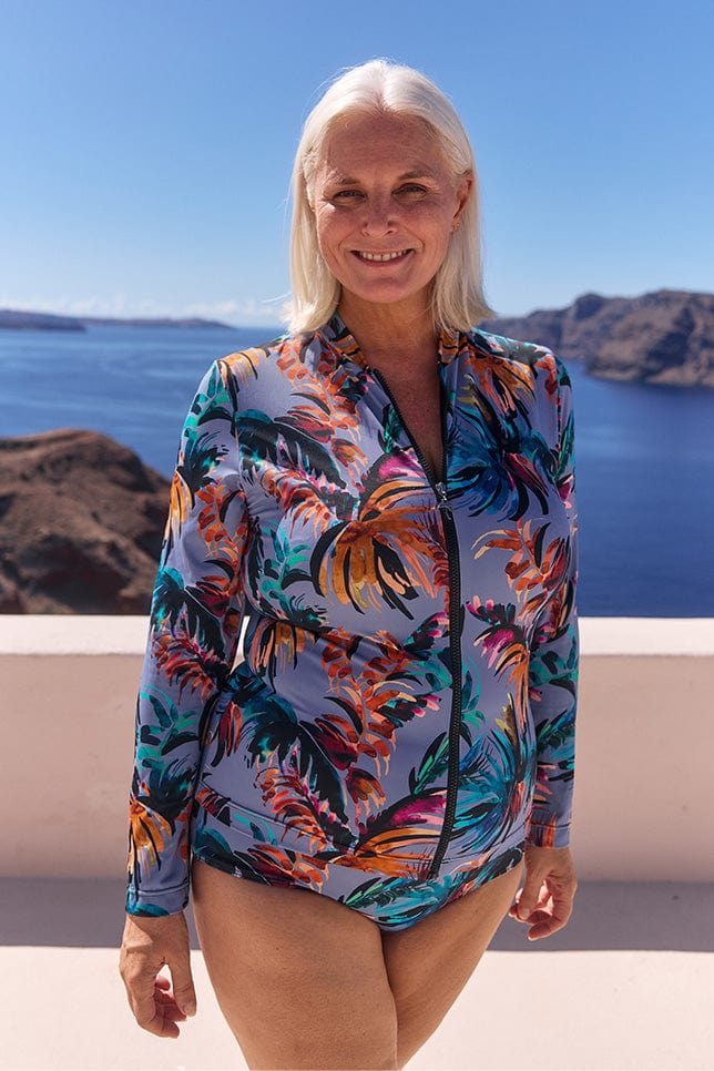 Model with white hair wearing sun safe long sleeve rash vest in floral print