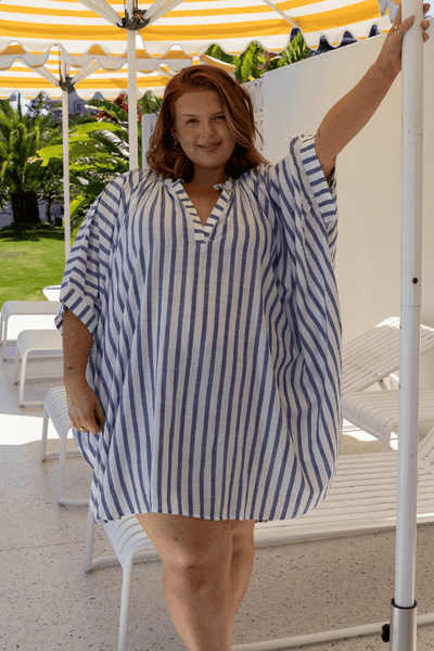 Orange hair model wearing blue and white striped beach overshirt with three quarter sleeves