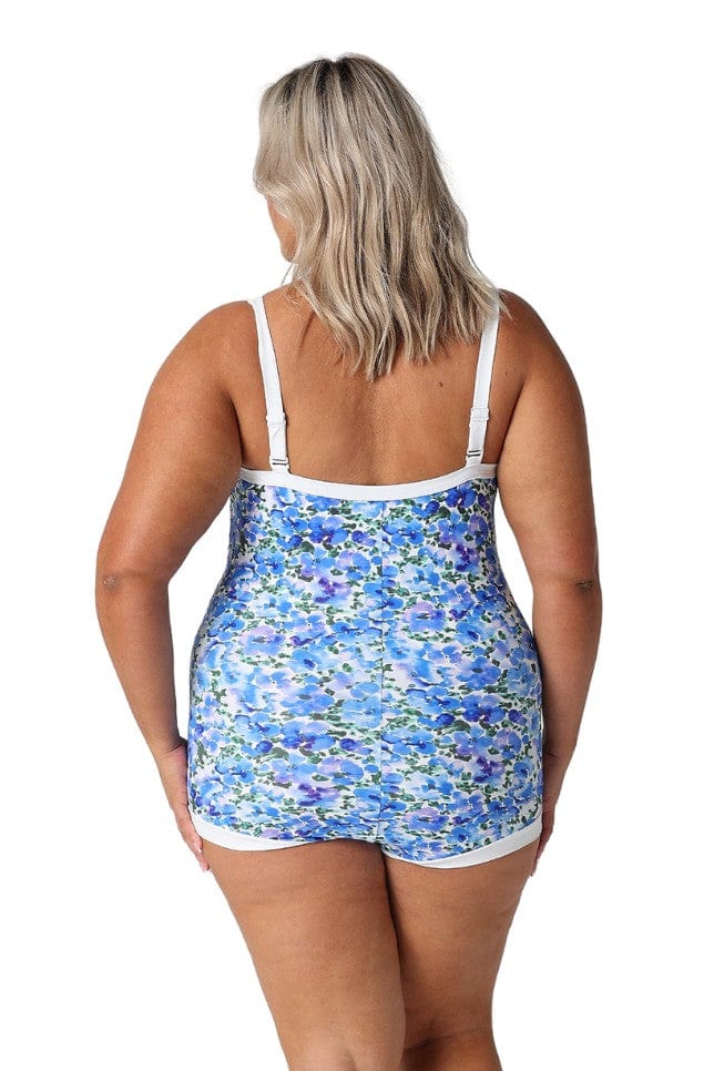 Back of model in studio showing off blue and white one piece in boyleg style with white trim