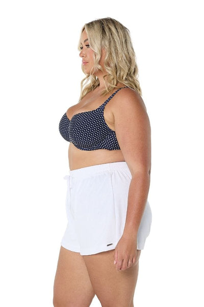 Blonde plus size model in studio wearing high waisted beach shorts in white terry towelling with drawstring