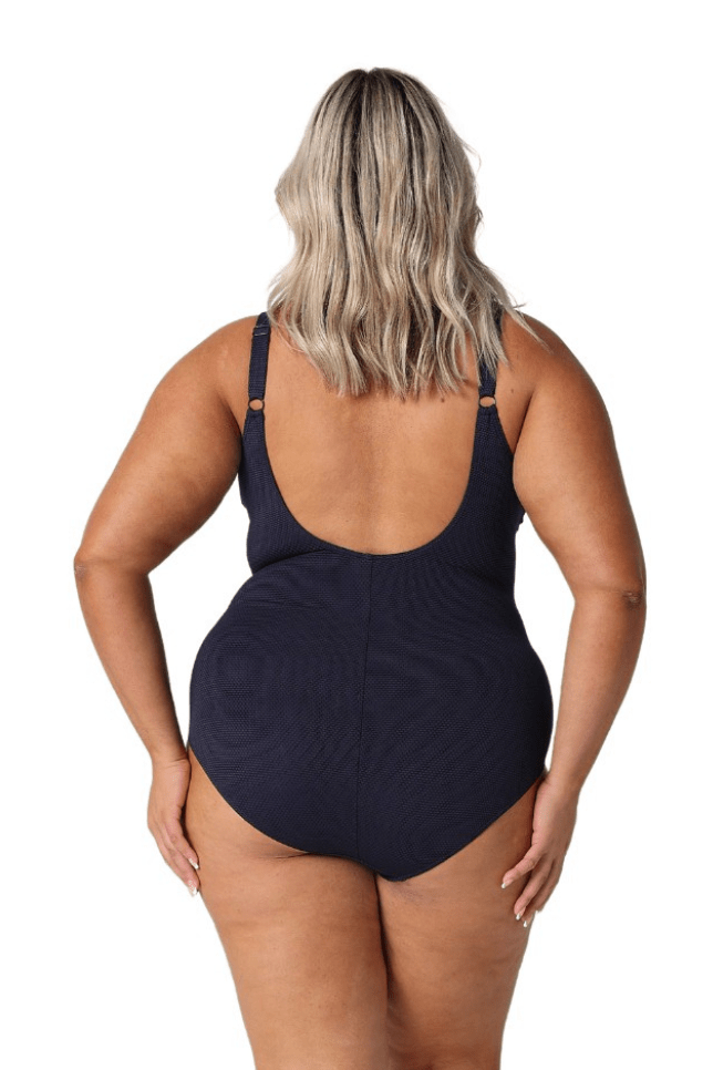 Back of model in studio wearing scoop back one piece in navy
