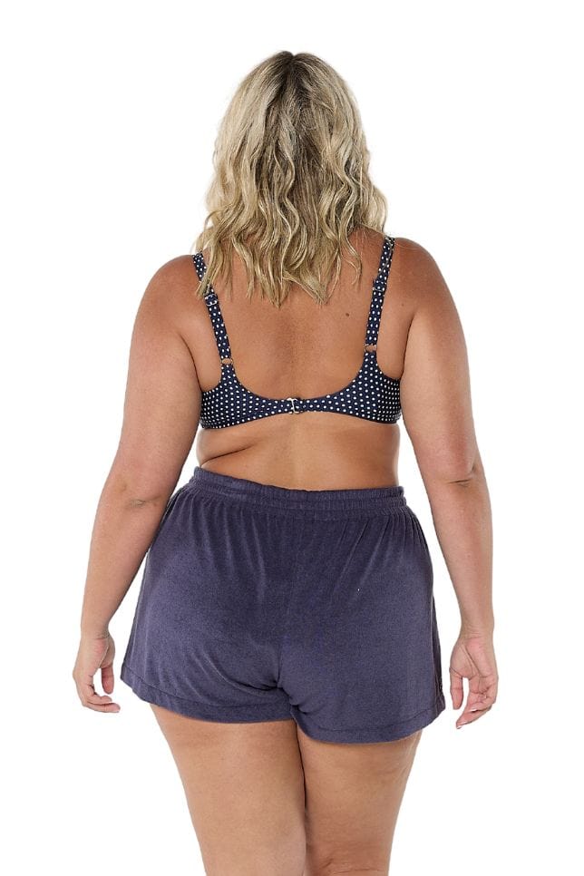 Back of model wearing plus size high waisted beach short in navy terry towelling