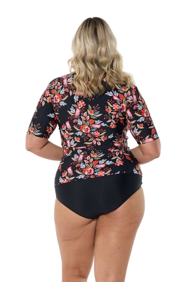 Back of model wearing beach swim coverup rash vest in pink wild berries print