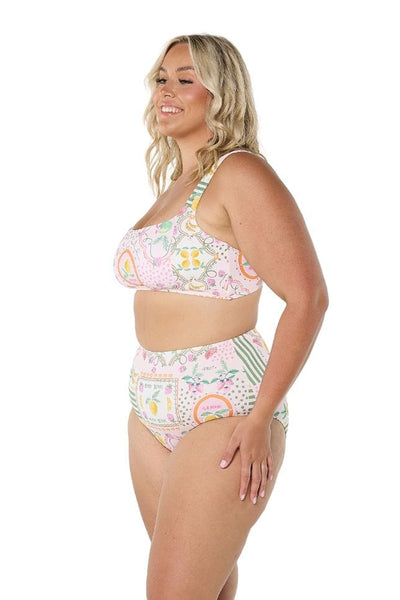 Side profile of model wearing flattering swim pants in tutti frutti fun multi coloured print