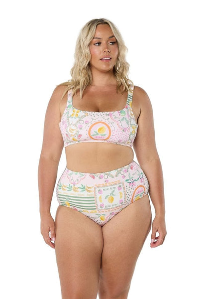 Front shot of model in studio wearing plus size pant in fun fruit coloured print