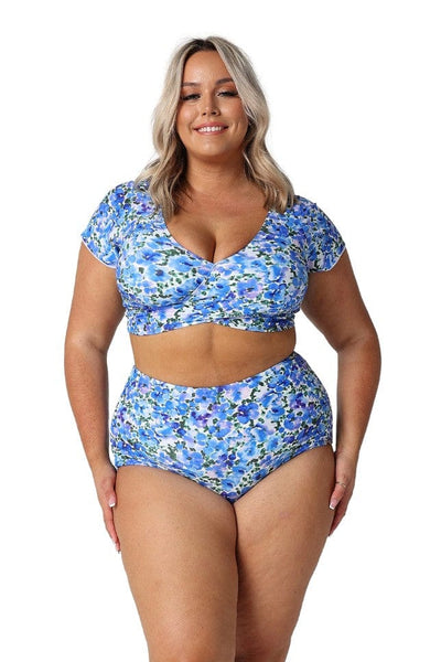 Model in studio wearing plus size bikini pant in blue floral print