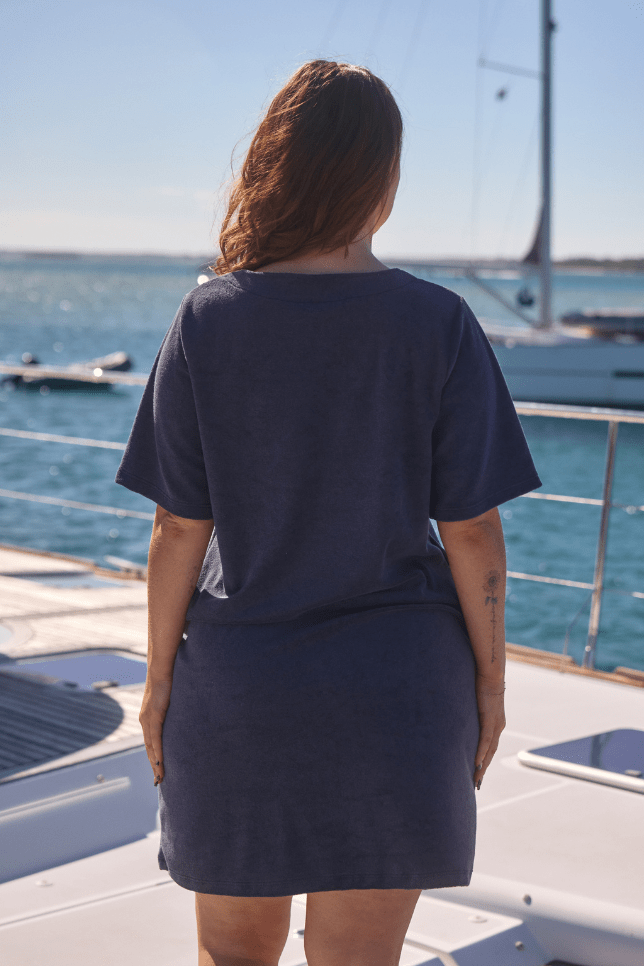 Back of brunette model wearing plus size terry towelling short sleeve dress with zip detail