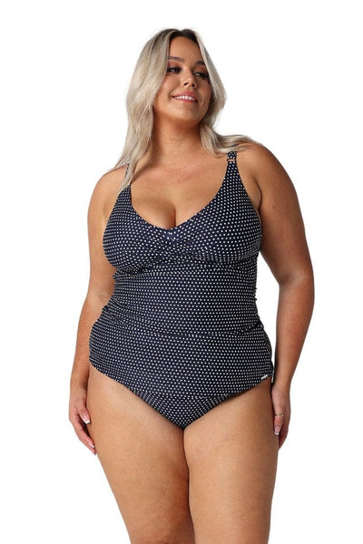 Blonde model in studio wearing v neck navy and white dots tankini for curve women