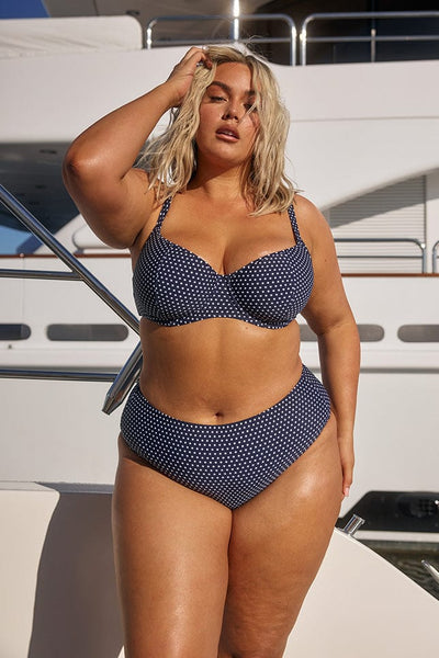 Blonde model wearing polkadot underwire bikini top in navy
