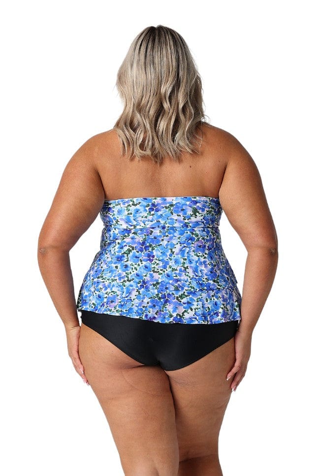 Blonde model in studio wearing plus size tankini top with ruffle details in blue and white watercolour blooms