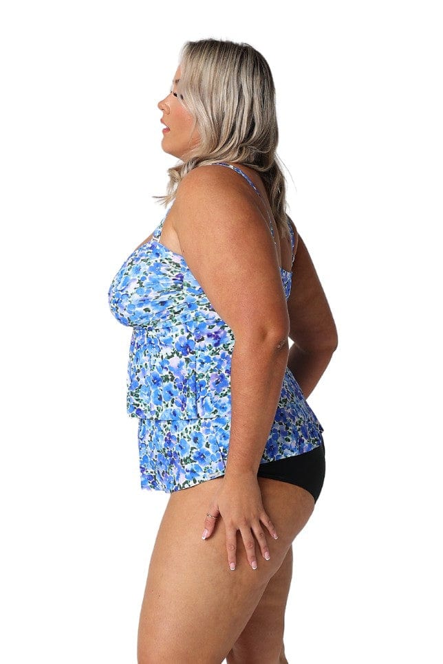 Side profile of plus size model in studio wearing ruffled tankini top with twist front detail bust