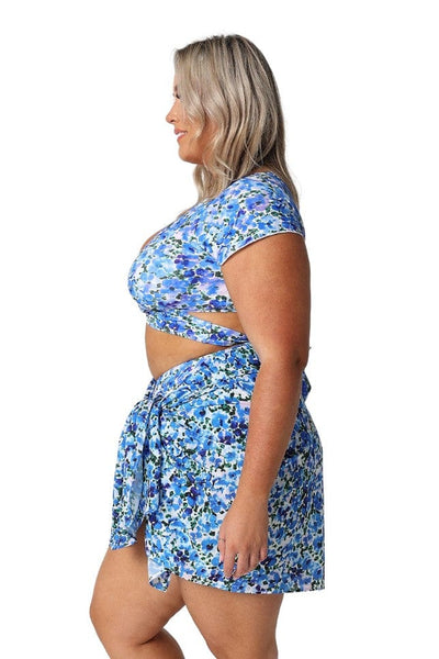 Side profile of blonde plus size model in studio wearing sarong skirt in blue