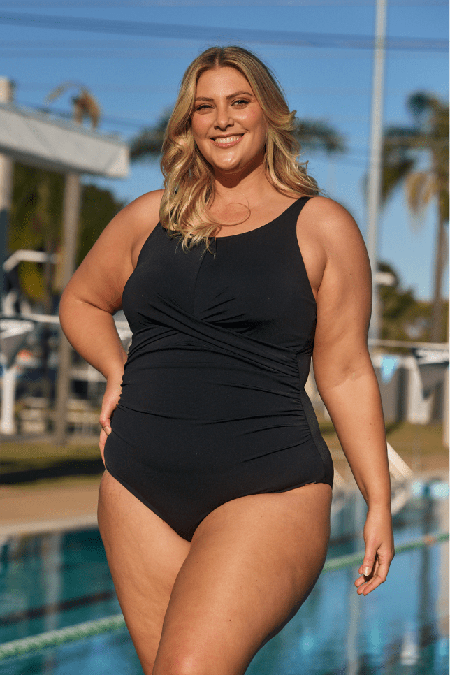 Blonde model by pool wearing high neck twist front one piece with ruching