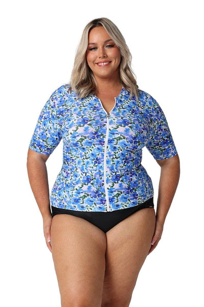 Front of model in studio wearing zip front rash vest in water colour floral print