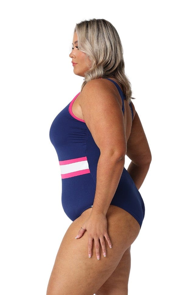 Model showing side of flattering pool proof swimsuit in navy with pink and white