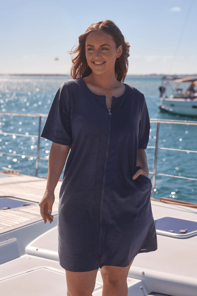 Front of brunette model on boat wearing plus size beach coverup in terry towelling fabric with zip detail