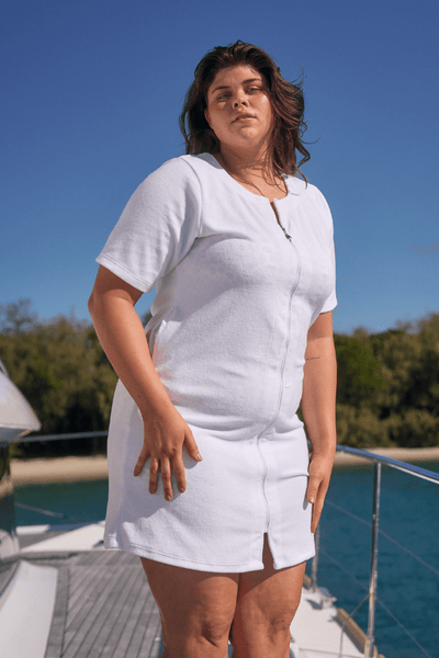 Brunette model on boat wearing curvy plus size zip through white terry towelling dress