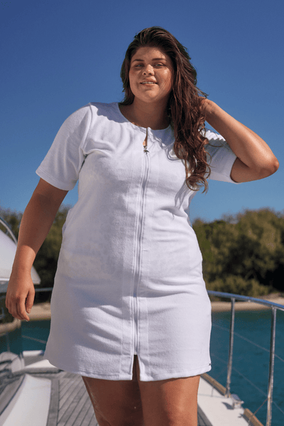 Brunette model on a boat wearing terry towelling beach coverup with zip-through detail