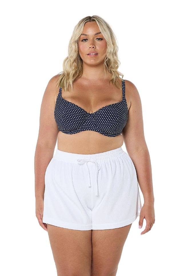 Blonde women wearing plus size high waisted terry towelling shorts
 in white