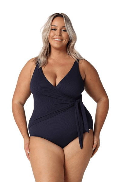 Blonde model in studio wearing navy textured one piece with side detail
