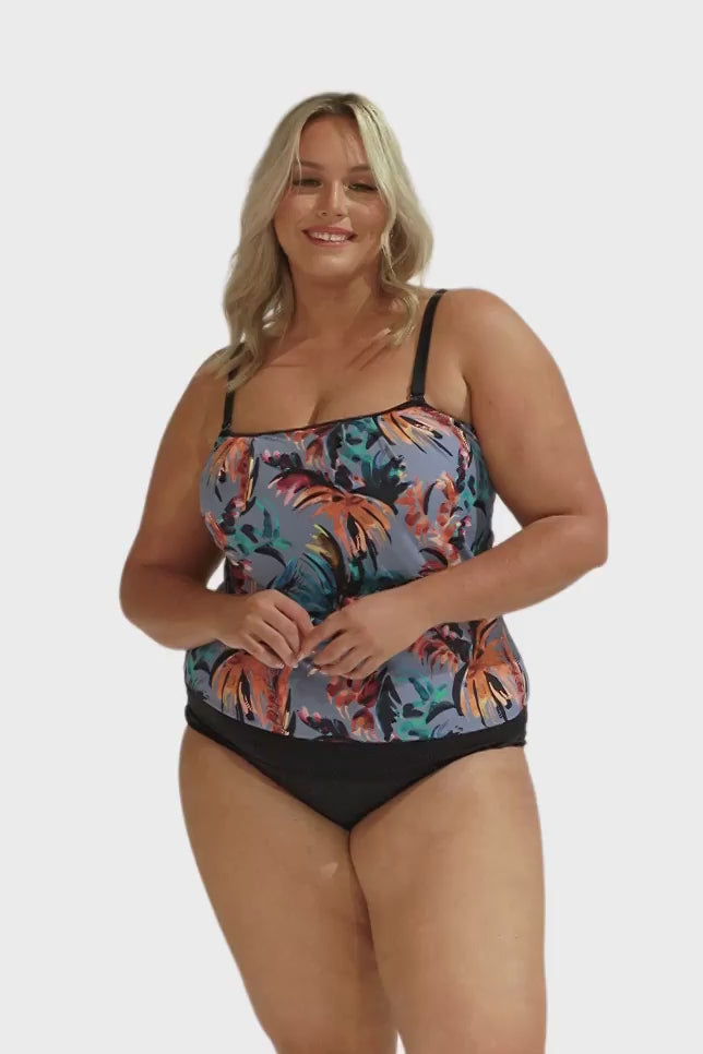 Video of model in studio showing flouncy bandeau tankini top with adjustable and removable straps