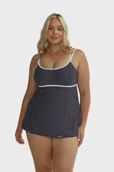 model wearing underwire swim dress in navy and white dots 