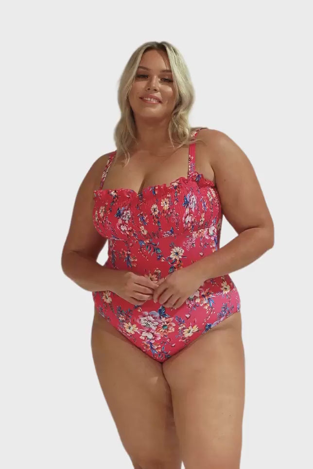 Model wearing hot pink floral shirred bandeau swimsuit