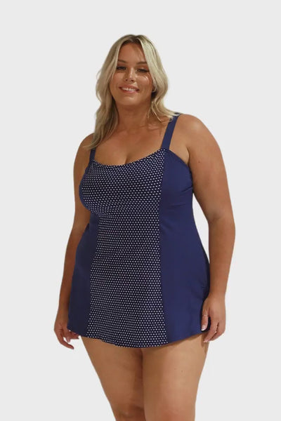 Blonde model in studio wearing navy polkadot swim dress for curve woman