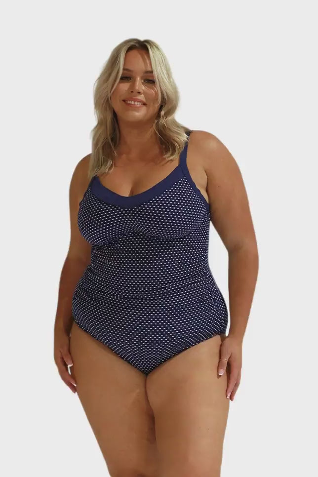 Video of blonde model wearing white and navy tummy control one piece with underwire and adjustable straps