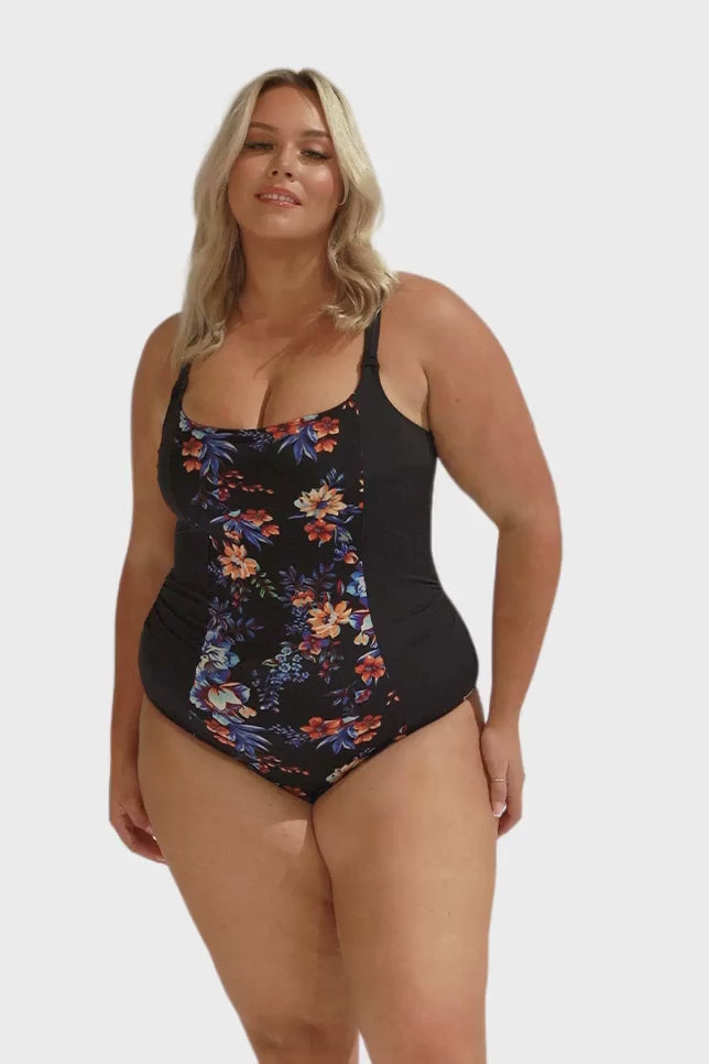 Video of model in studio wearing black orange and blue floral printed one piece for curve women