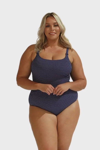 brunette plus size model wears navy and white dots tank tankini top with low scoop back