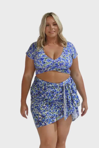 Blonde model showing video of sarong on body in blue and white water coloured print