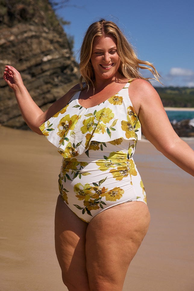 model wearing white and yellow frill one piece on beach